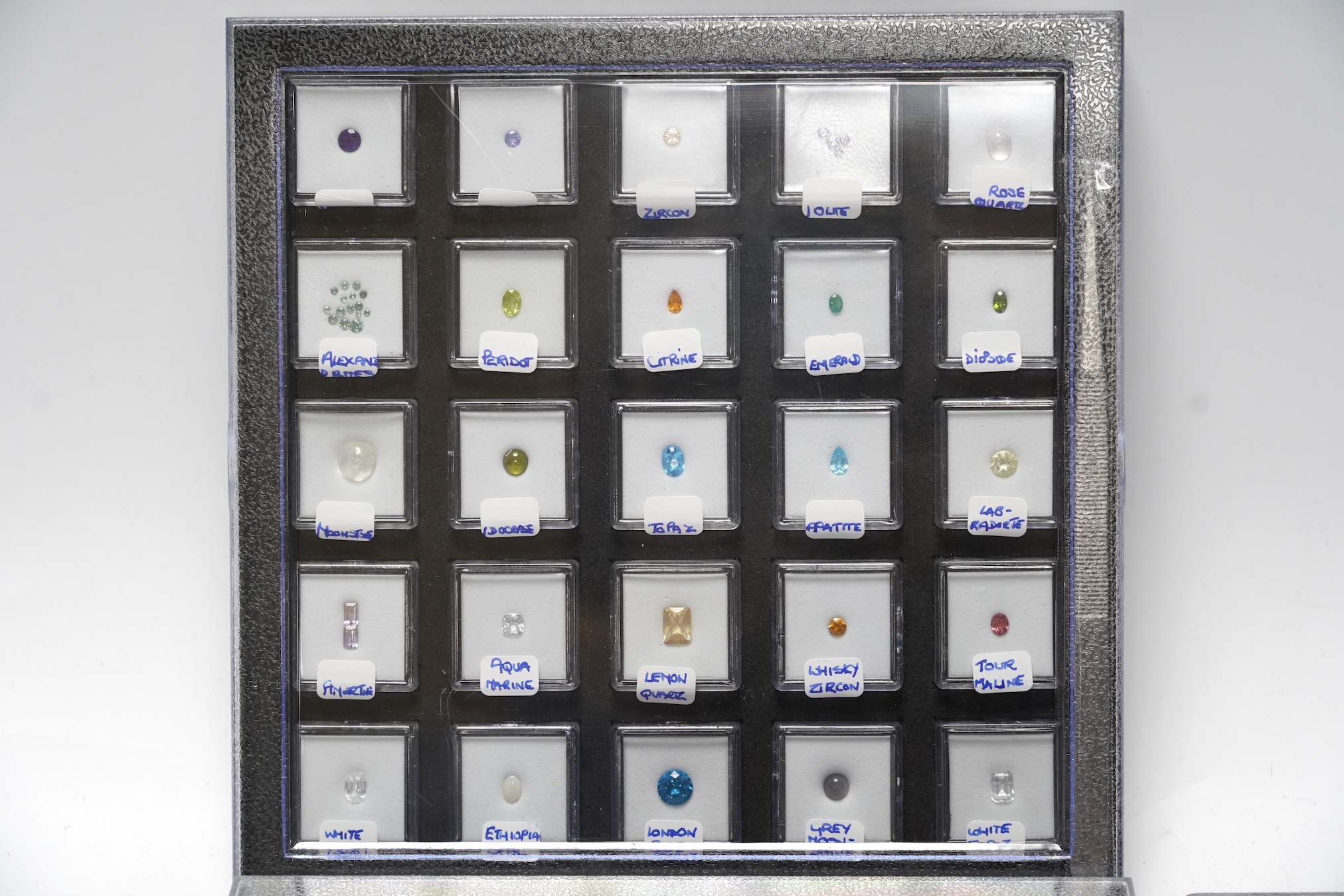 Three boxes containing unmounted cut gemstones including topaz, citrine, peridot, zircon, moonstone, etc. Condition - fair